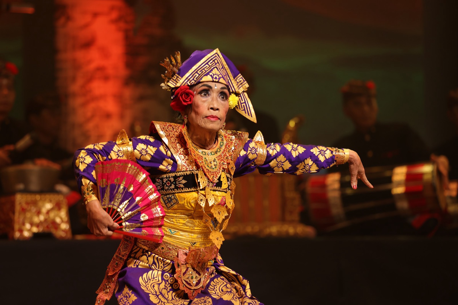 A Balinese dancer with a fan, mid-performance