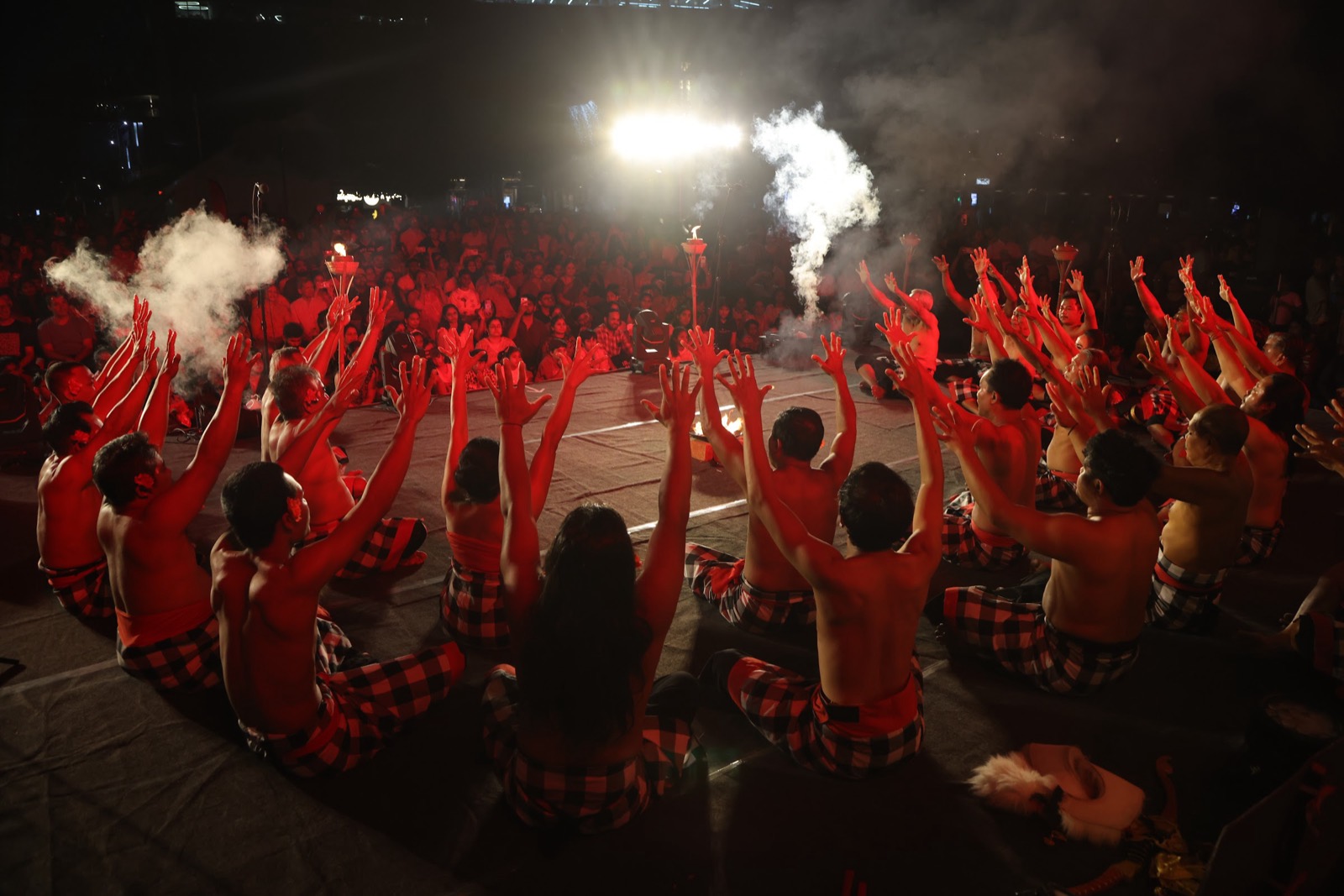 The Kecak chorus raises its arms around the fire on opening night